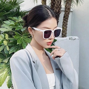 Detail of white chunky square frame sunglasses with dark purple lenses and metal accents