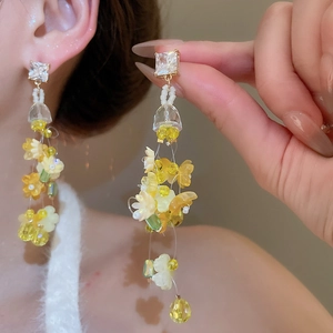 Detail of floral tassel earrings with yellow crystal beads and gradient petal design