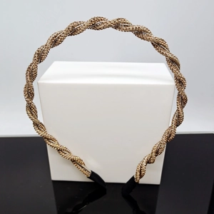 Close-up of twisted headband with bronze crystal beads on a white pedestal display