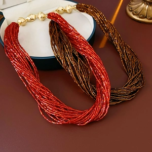 Dettaglio macro della collana di perline multistrato con perline rosse, bronzo e sfere d'oro