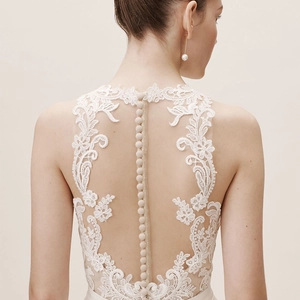 Elegant white satin wedding dress featuring detailed lace embroidery and a buttoned back