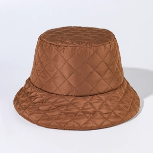 Detail of a brown quilted bucket hat with a diamond pattern and glossy finish