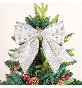 Close-up of a silver glitter Christmas bow with sequins on a festive tree branch