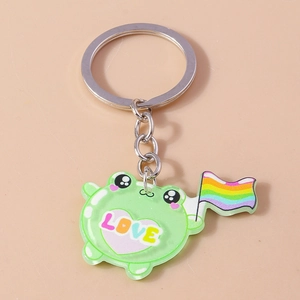 Detail of cute green acrylic frog keychain holding a rainbow flag with Love text
