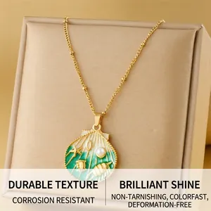 Macro view of gold seashell pendant with green enamel, small pearls and starfish detail