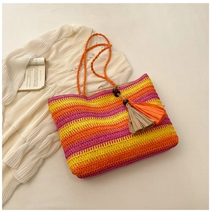 Detailed texture of a colorful striped straw tote bag featuring decorative wooden bead tassels