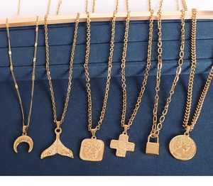 Detailed close-up of six gold-plated necklaces featuring coin, moon and cross pendants