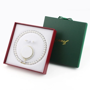 Elegant white pearl jewelry set with necklace and bracelet in a luxury green gift box