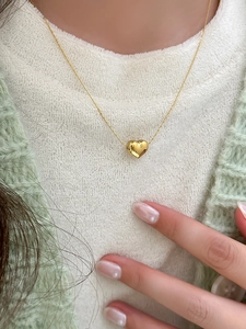 Close-up of heart-shaped gold pendant on tarnish-free stainless steel necklace chain