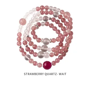 Detail of strawberry quartz beaded bracelet with silver hollow charms and red accent bead