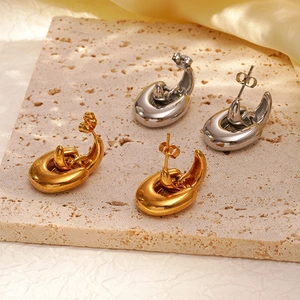 Retro geometric 18K gold and silver stainless steel earrings on a stone tray
