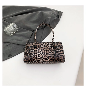 Detail shot of leopard print handbag resting on a grey blazer with stylish home decor