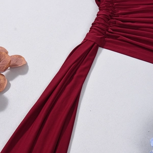 Détail du tissu froncé bordeaux avec de longs liens et une texture mate raffinée