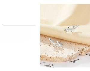 Detail of silver leaf stud earrings on satin with 3-layer gold plating quality text