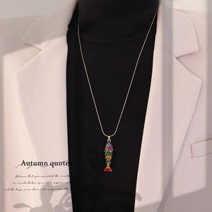 Detail of a vintage 3D koi fish pendant with colorful enamel on a long golden chain