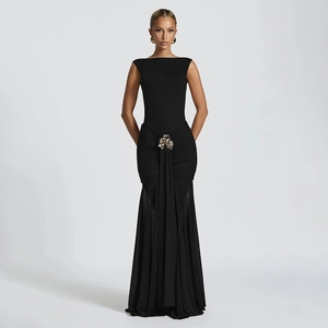 Detail of elegant black sleeveless dress with waist pleats and gold buckle accent
