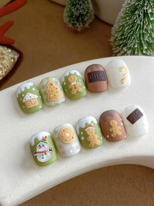 Macro detail of 3D embossed Christmas gingerbread man and chocolate resin nail art stickers