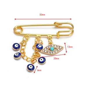 Detailed view of gold safety pin brooch with blue evil eye charms and size specs
