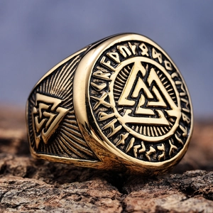 Macro detail of gold Viking Valknut ring with rune carvings on aged wood background