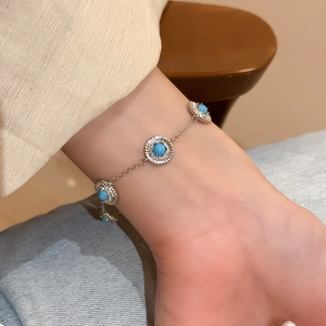 Détail du bracelet chaîne argenté avec breloques turquoise et pierres de zircone