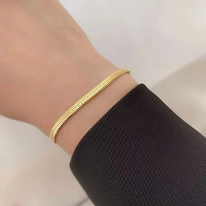 Close-up of golden braided snake chain bracelet showing refined texture and metallic shine