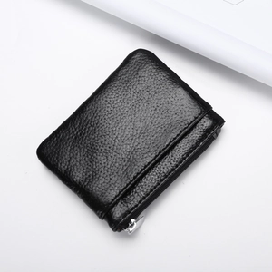 Detail of black pebbled leather coin purse with metallic zipper on white background