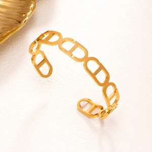 Elegante bracciale rigido dorato con maglie a incastro traforate su sfondo bianco
