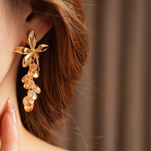 Detail of vintage flower tassel earring with amber crystal beads on a female model