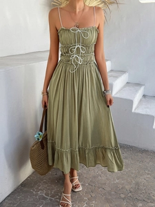 Olive green A-line dress with spaghetti straps and ruffled hem shown on a model