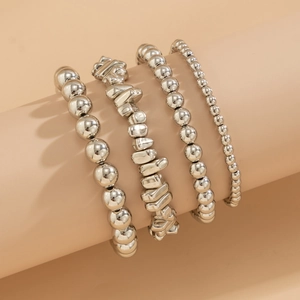 Detail view of 4-piece silver bead bracelet set with heart pendant on a display stand