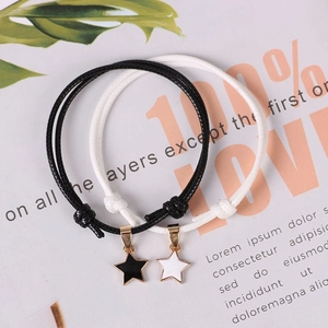 Adjustable wax rope star bracelets in black and white with gold-edged star charms