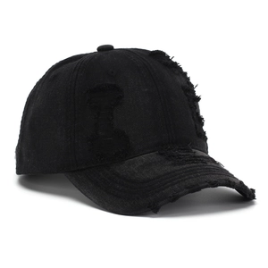 Detailed close-up of distressed denim baseball cap showing vintage ripped holes and frayed edges