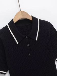 Detail of black cable-knit Polo shirt with white contrast stripes on collar and cuffs