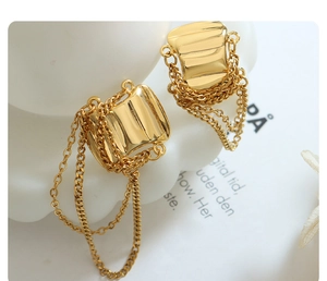 Detailed macro view of gold plated geometric earrings with multi-layer hanging fringe chains
