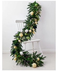 Detail of 1.8m Christmas garland with champagne balls and LED lights on a white chair
