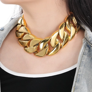 Polished gold 43mm wide chunky Cuban link chain necklace worn with denim jacket