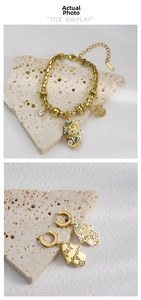 Detail van gouden boze oog hamsa armband en oorbellen met S.STEEL gravering