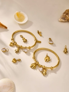 Detailed macro view of 18k gold plated bracelets with heart, elephant, and bear charms