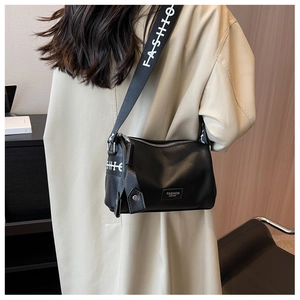 Detail of black lychee grain leather crossbody bag with wide white logo shoulder strap