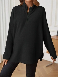 Detail of black maternity sweatshirt featuring quarter zip neck and warm fleece texture