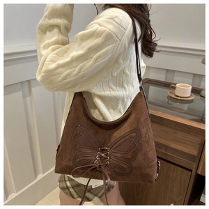 Close-up of brown suede tote bag featuring artistic 3D bow ribbon decorative details