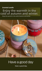 Detailed view of scented candles in decorative tins with floral petals on bamboo mat