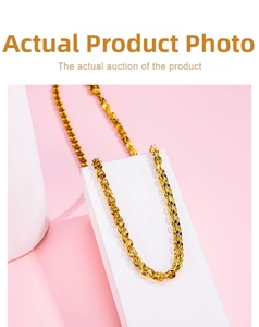 Close-up of golden wheat chain bracelet displayed on white geometric props over pink backdrop