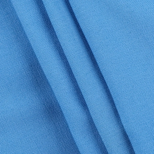 Gros plan sur un tissu bleu à tissage dense montrant une texture et un drapé lisse