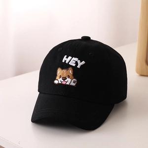 Dettaglio del ricamo Shiba Inu e HEY su un cappellino in cotone nero per bambini