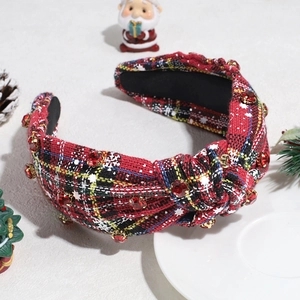 Close-up of red plaid headband with rhinestones and beads in Christmas decor scene