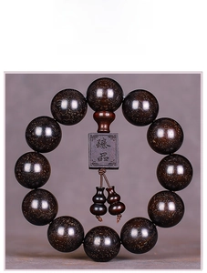Detailed view of high-density blood sandalwood prayer beads with golden specks and gourd charms