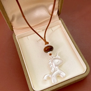 Détail du pendentif licorne en argent avec perle brune dans son coffret à bijoux élégant