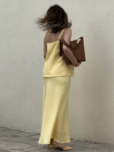Detail of yellow cotton camisole and fishtail skirt set with linen texture finish