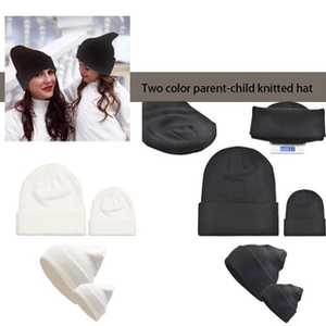 Detail view of black and white parent-child knitted hats showing texture and weight